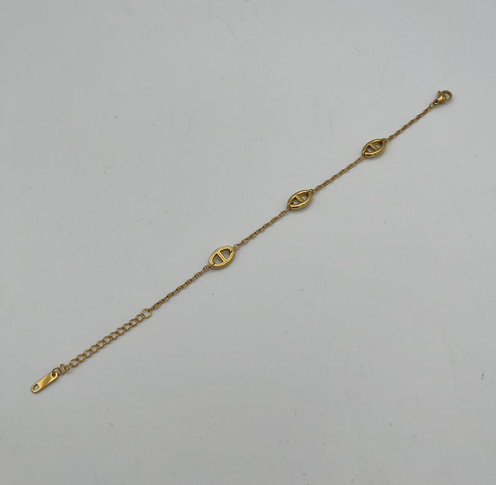 Gold chain bracelet with three oval cutout charms and adjustable extender