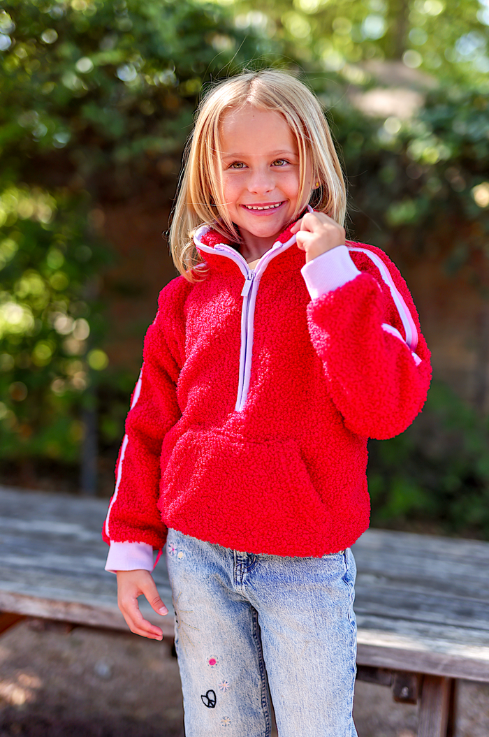 Cozy red fleece hoodie for kids with a front pocket and zipper, perfect for chilly days.