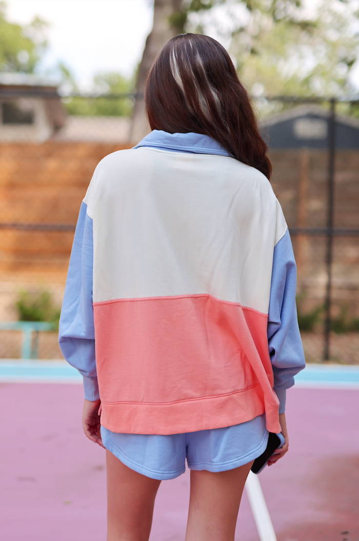 Women's color-blocked sweatshirt in blue, white, and coral, featuring a relaxed fit and soft material.