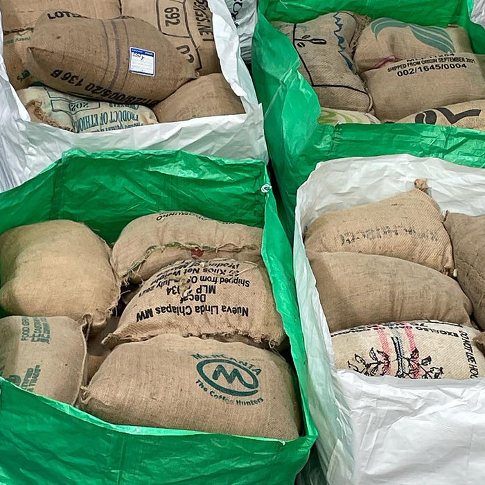 Green and white wool bags full of coffee sack cushions.