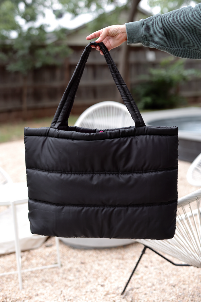 Black padded tote bag with sturdy handles, perfect for everyday use and stylish storage.