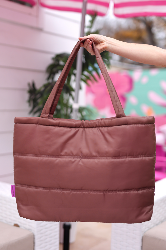 Stylish brown quilted tote bag with sturdy handles, perfect for daily use or casual outings.