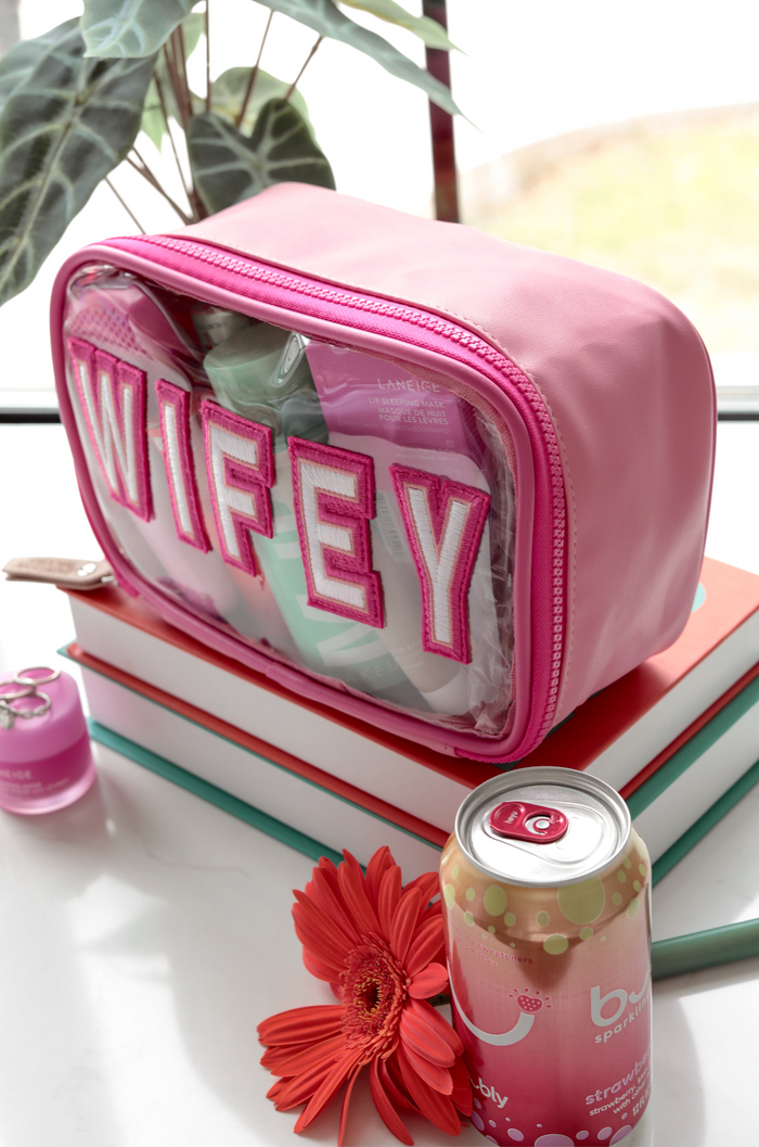 Pink WIFEY cosmetic bag with transparent pouch, stylish and functional for beauty essentials.