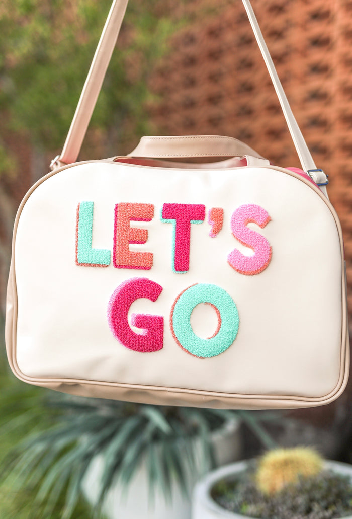 Light pink duffel bag with colorful 'LET'S GO' embroidery, perfect for travel or gym.