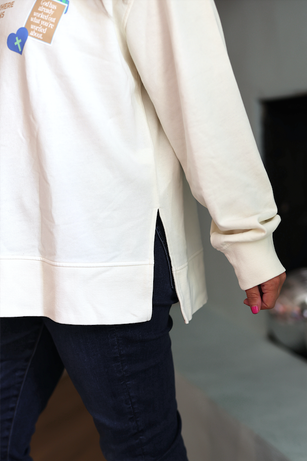 Cream oversized sweatshirt with side slits, perfect for casual wear and easy layering.