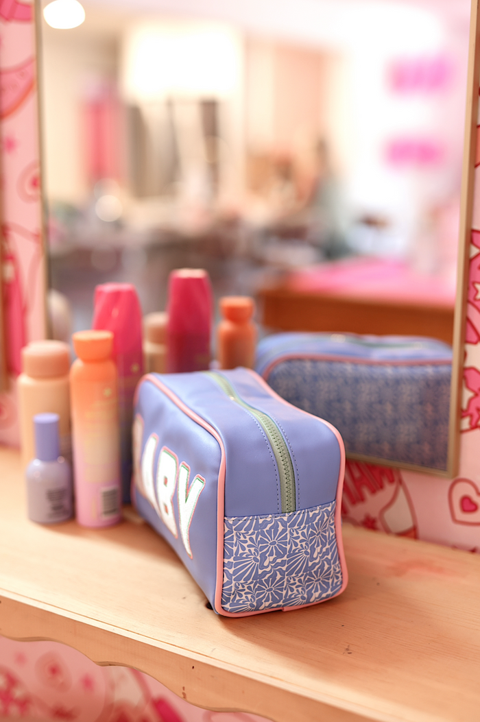 Blue cosmetic bag with floral design, zipper closure, and 'BABY' text, perfect for organizing makeup.