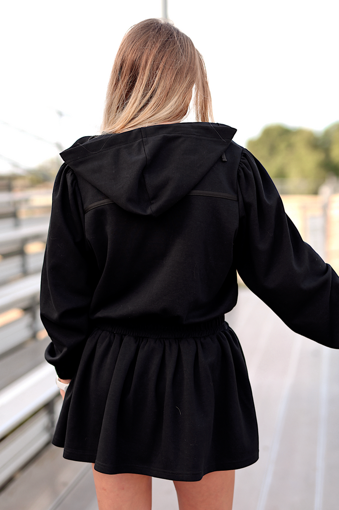 Black hoodie dress with elastic waist and hood, perfect for casual wear or lounging.