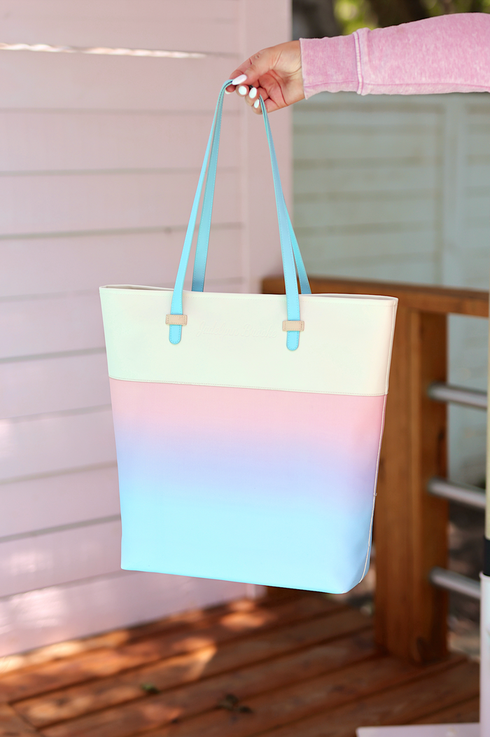Stylish tote bag in pastel gradient, featuring durable material and light blue handles.