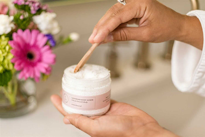Lavender Body Scrub - Woman scooping natural salt scrub from jar with spoon | Lizush