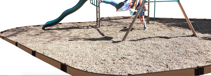 Curved playground border with wood chip safety surfacing around swing set and two children playing