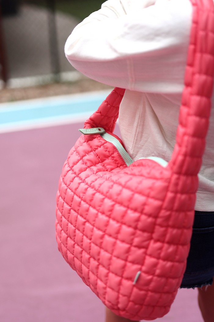 Bright pink quilted shoulder bag with zipper, perfect for casual outings and stylish convenience.