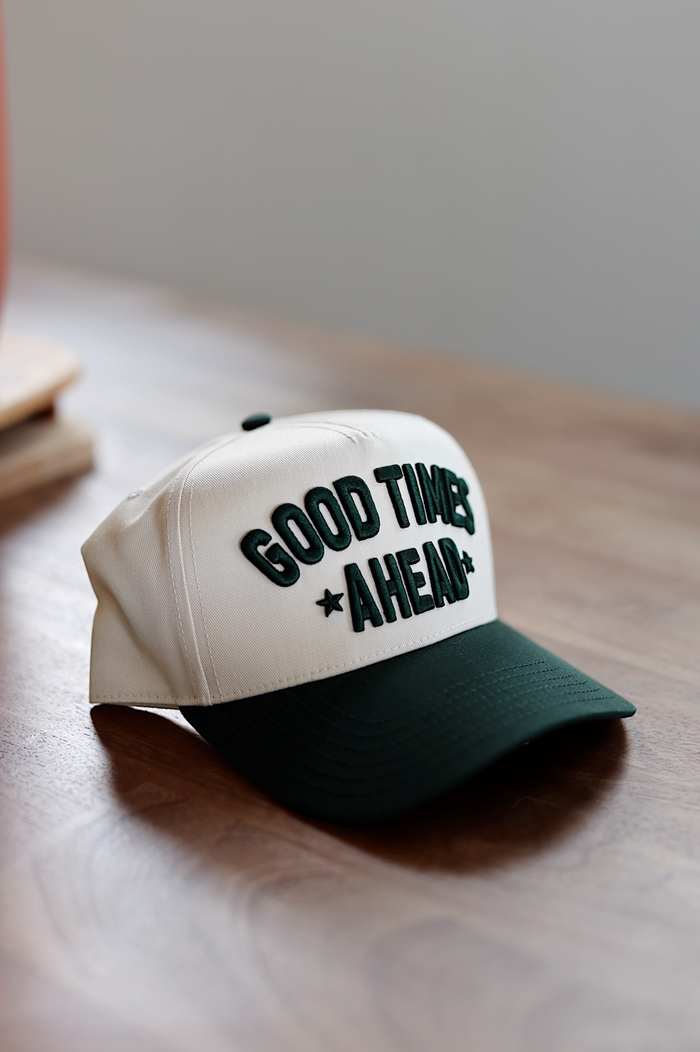 Beige baseball cap with green 'GOOD TIMES AHEAD' embroidery, perfect for casual outings.