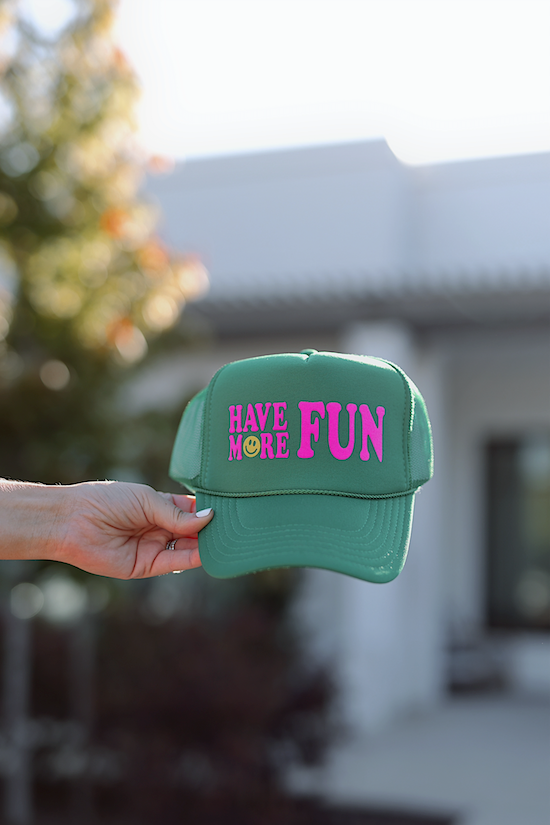 Green cap with 'HAVE MORE FUN' text in pink, perfect for casual wear and outdoor activities.