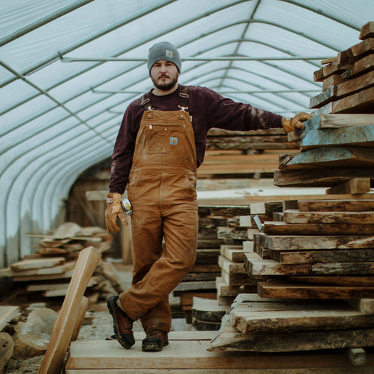 Carhartt 102776-211&nbsp;Relaxed Fit Duck Bib Overall in Carhartt Brown image of worker wearing it