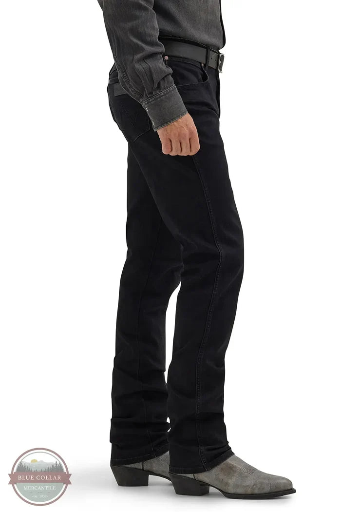 Person wearing black pants and gray shoes on a white background Wrangler 112358240 Retro Slim Fit Straight Leg Jean side view