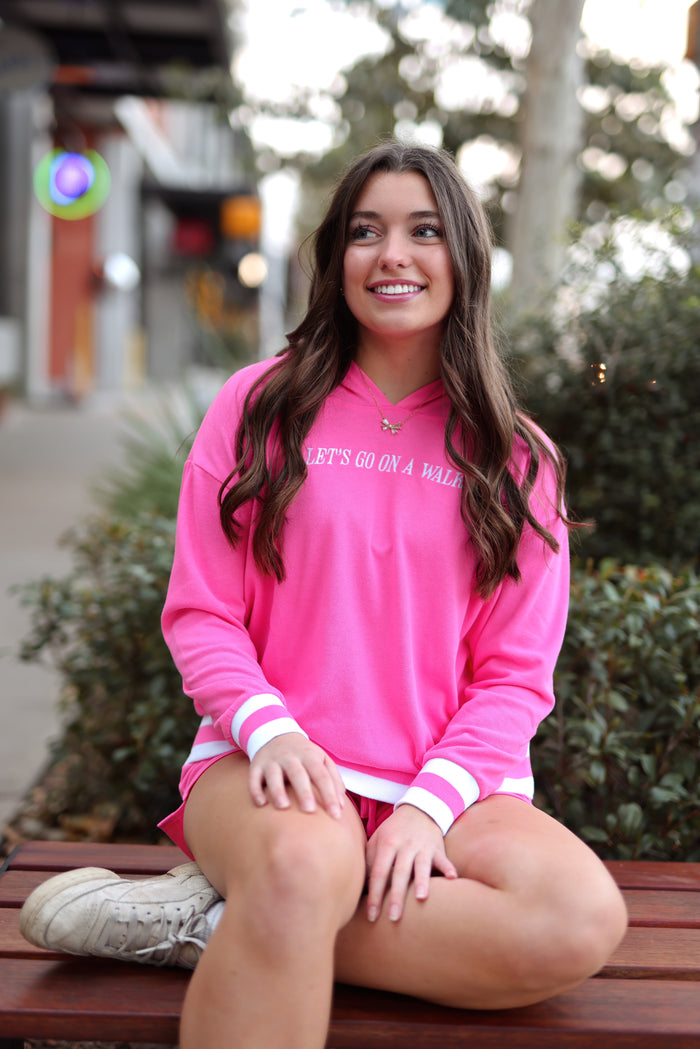 Bright pink hoodie with 'Let's Go On A Walk' print, paired with shorts, perfect for casual outings.