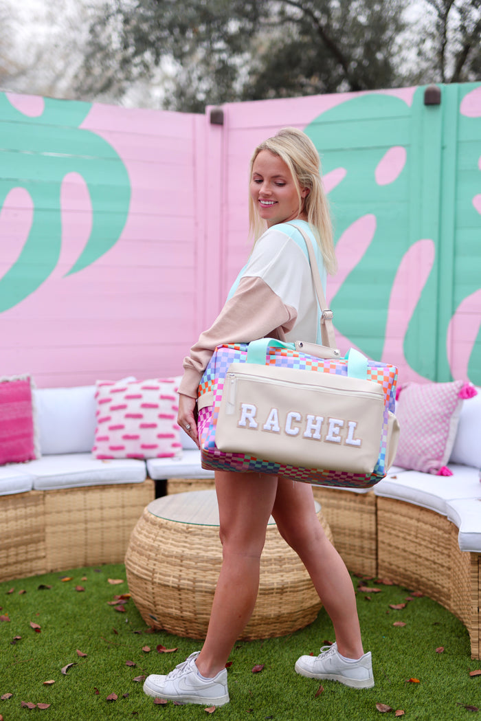 Colorful checkered duffel bag with personalized name 'RACHEL', perfect for travel or gym.