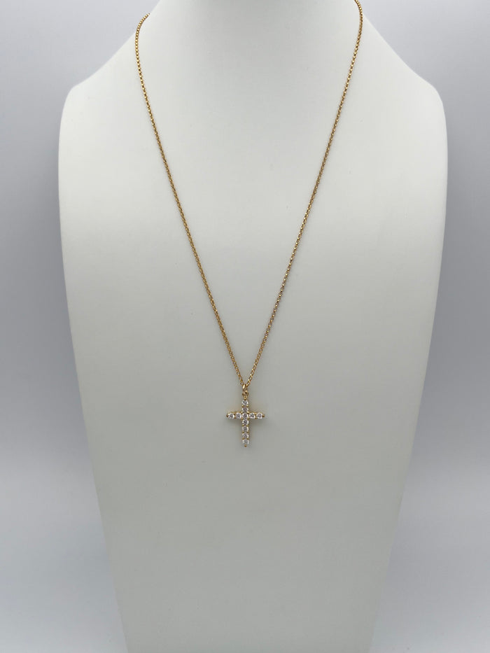 Gold chain necklace with crystal cross pendant displayed on white jewelry bust