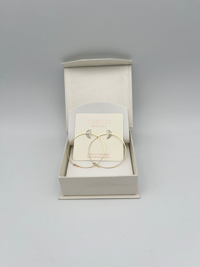 Gold hoop earrings in cream jewelry box from Idlewild Everyday brand