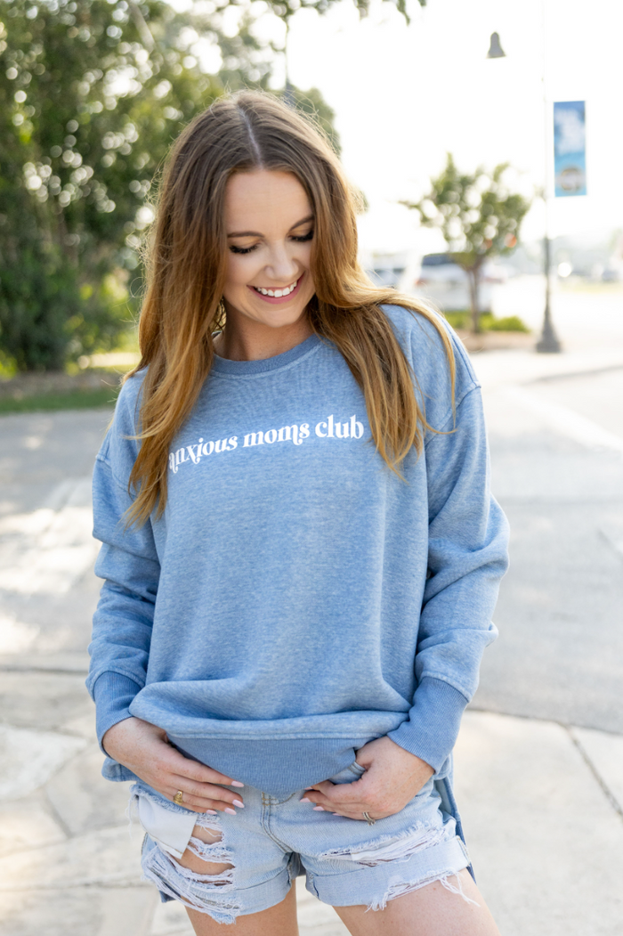 Light blue sweatshirt with 'anxious moms club' print, cozy and stylish for casual wear.