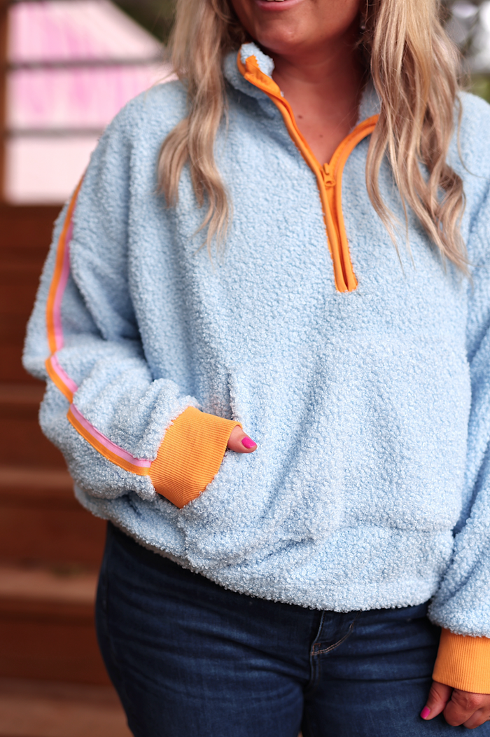 Light blue fleece pullover with orange accents, perfect for casual wear and cozy comfort.