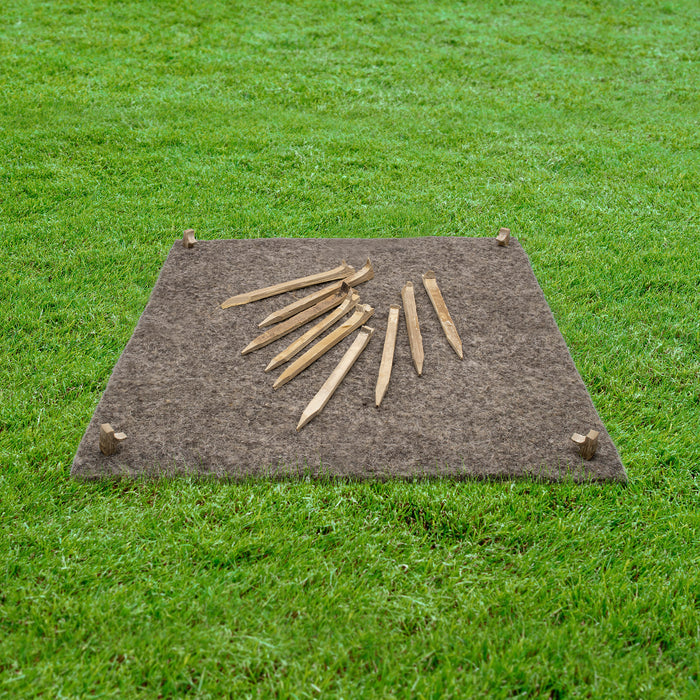 Sheepwool felt mulch mat with bamboo pegs on a grassy background