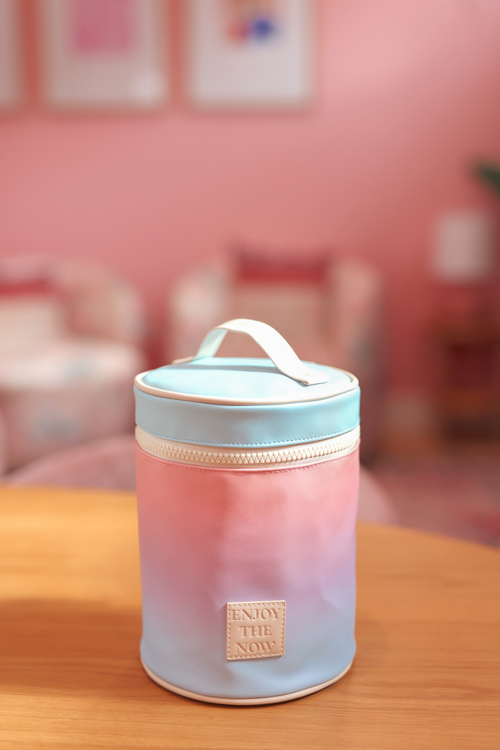 Trendy pastel gradient storage canister with handle, zip closure, and 'Enjoy the Now' patch. Ideal for decor.