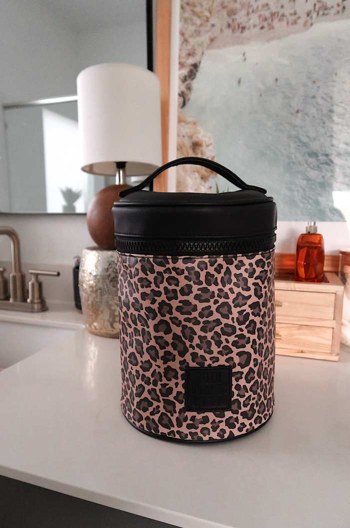 Leopard print round cosmetic bag with black zipper and handle, perfect for stylish organization.