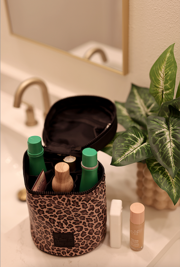 Leopard print cosmetic bag with green and brown bottles, perfect for organizing beauty products.