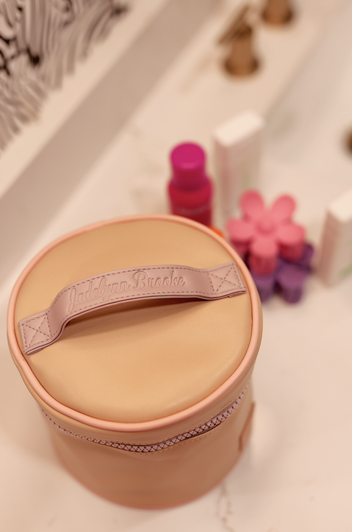 Pink cosmetic storage case with handle, stylish design, perfect for organizing beauty products.