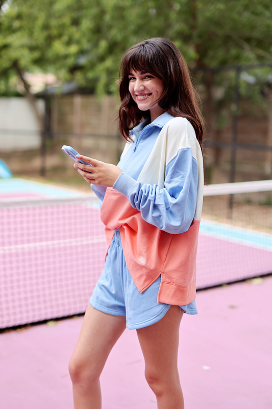 Casual women’s color-blocked sweatshirt in blue and coral, featuring long sleeves and a relaxed fit.