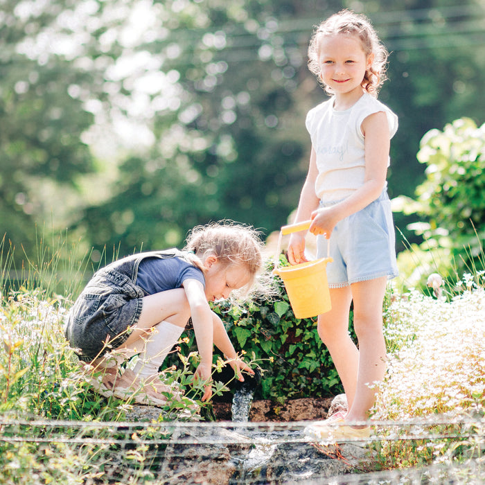 Girls with plastic free bucket and spade