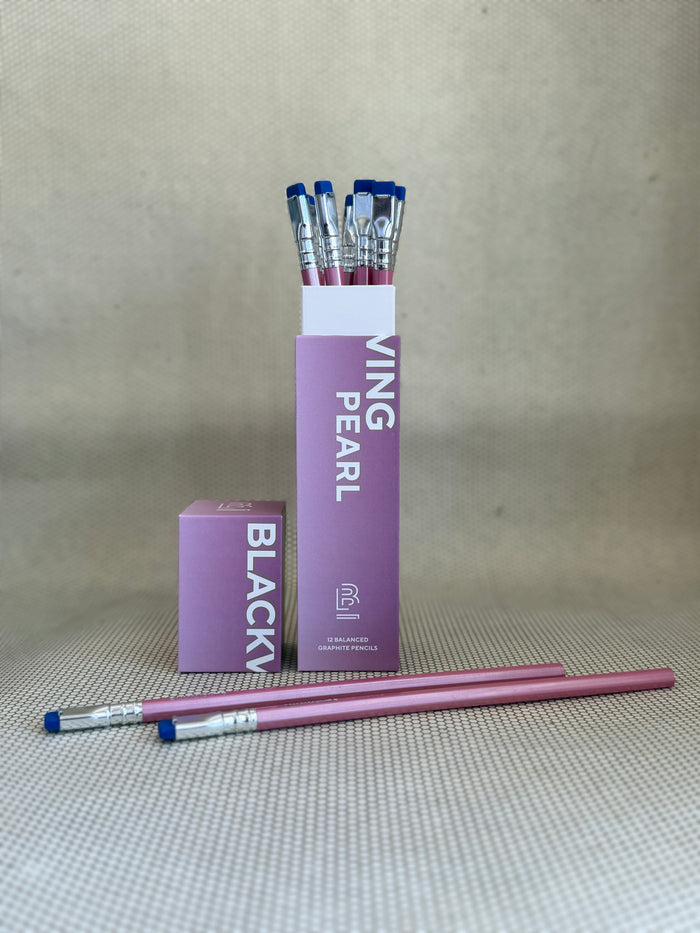 pink box of Blackwing pearl pencils with blue erasers and pink shells on neutral background.