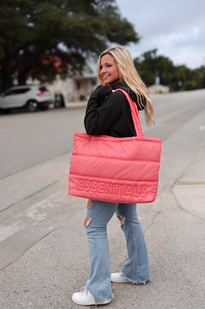 Coral pink padded tote bag with 'ESSENTIALS' logo, perfect for stylish everyday use.