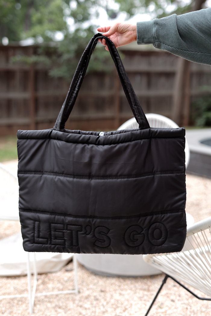 Stylish black quilted tote bag with 'LET'S GO' text, perfect for everyday use.