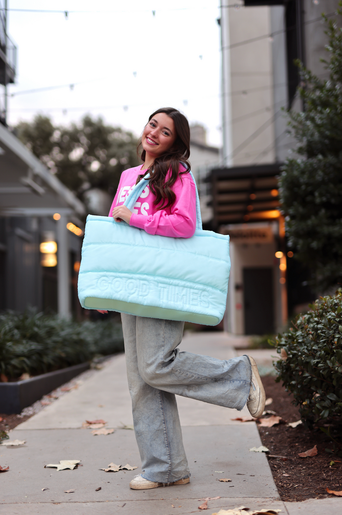 Stylish blue quilted tote bag with 'GOOD TIMES' text, perfect for casual outings.