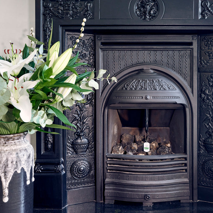 Chimney Sheep draught excluder inserted into a fireplace with the handle and safety tag visible.