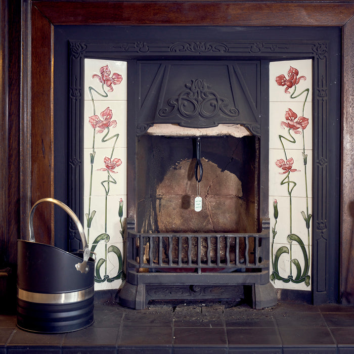 A Chimney Sheep handle and safety tag hanging down from an open fireplace.