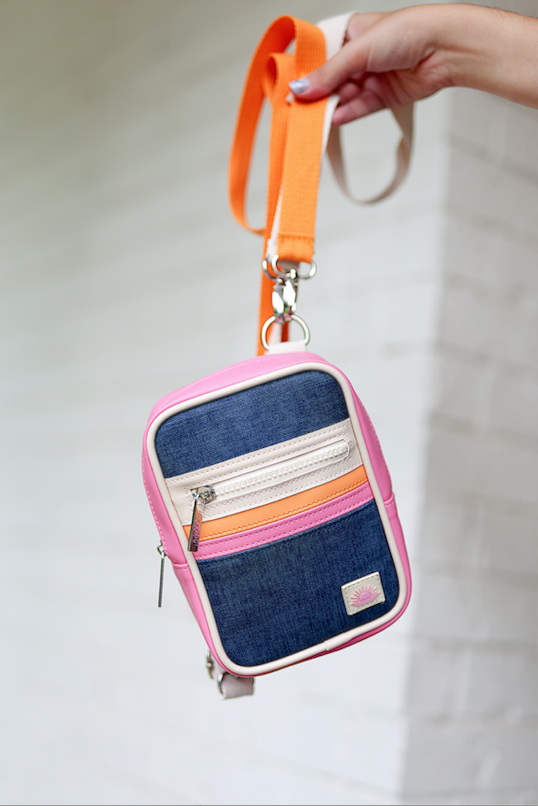 Colorful denim crossbody bag with pink, orange, and cream accents and adjustable strap.