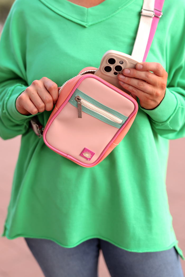 Trendy pastel pink and peach crossbody bag with zipper, perfect for smartphones and essentials.