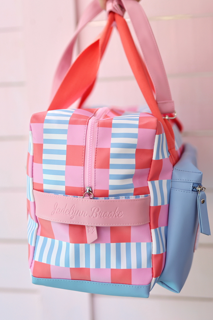 Colorful checkered tote bag in pink, blue, and red with faux leather material and embossed logo.