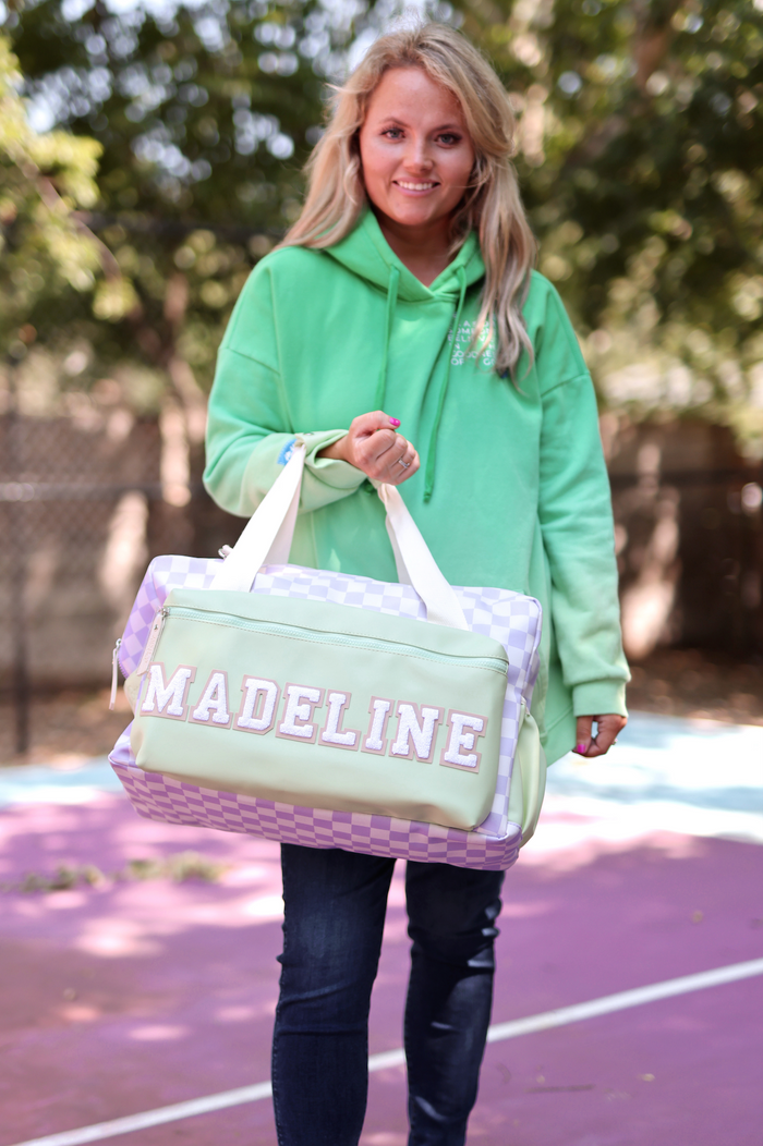 Stylish green and purple checkered travel bag with personalized name 'MADELINE', perfect for on-the-go.