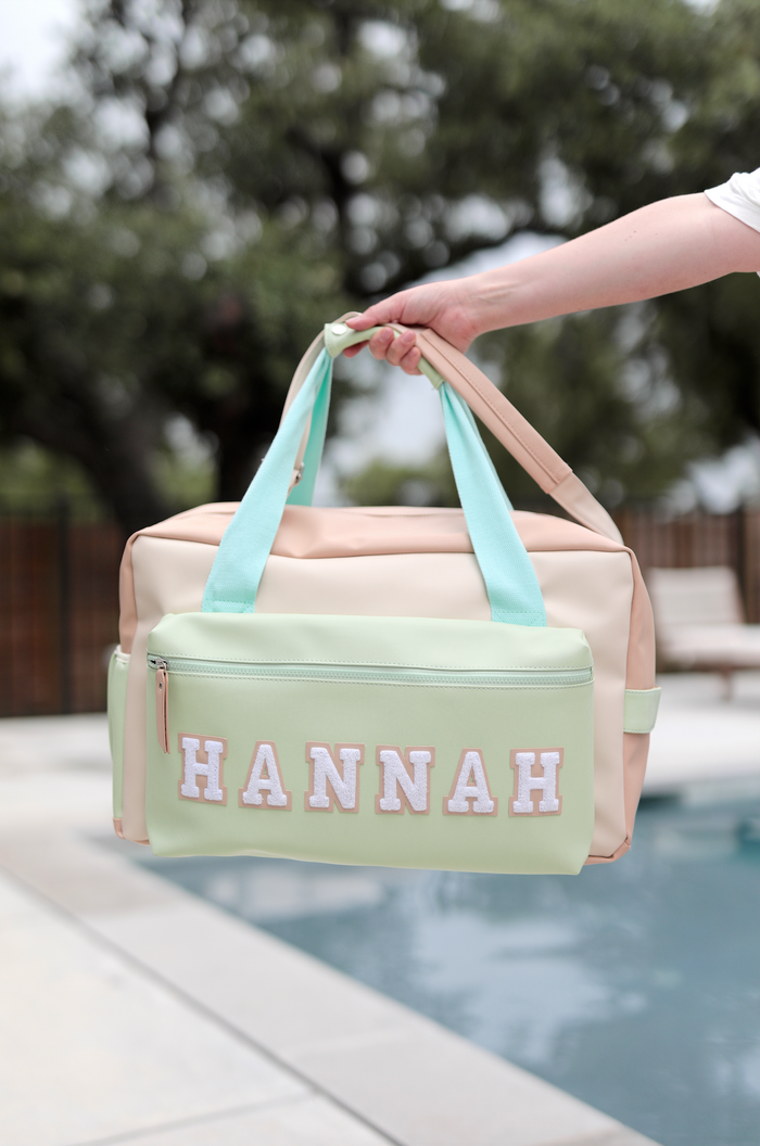 Personalized pastel tote bag with mint and peach colors, featuring a front zip pocket and name embroidery.