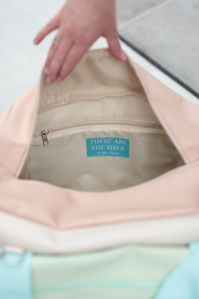 Peach and teal canvas tote bag interior with zipper pocket and 'These Are The Days' label.