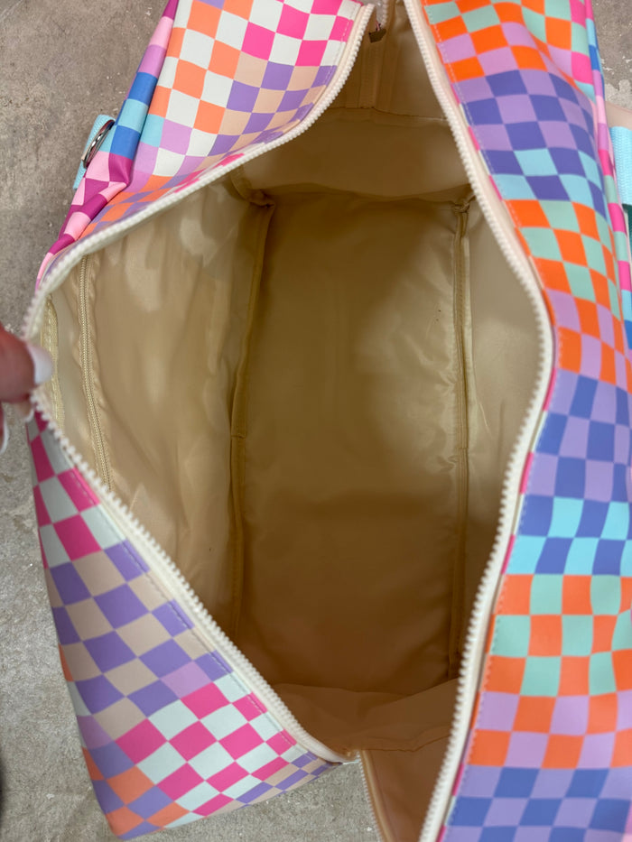 Colorful checkered duffel bag with pink, orange, and purple design, featuring a spacious cream interior.