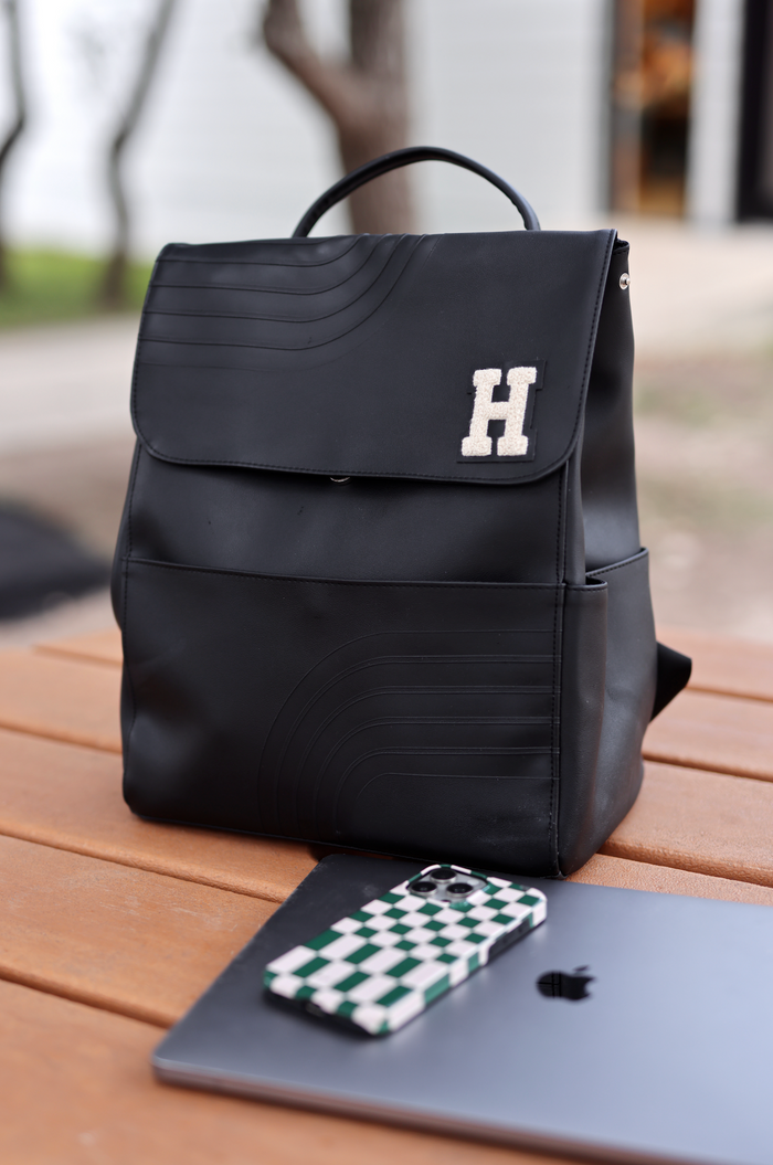 Stylish black backpack with embossed design and letter H, perfect for daily use.