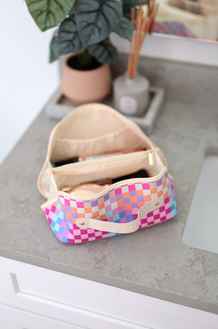 Colorful checkerboard makeup bag with pink, blue, and purple design, perfect for organizing cosmetics.