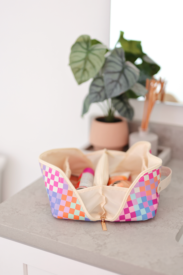 Colorful checkered makeup bag in pastel colors with multiple compartments for organization.