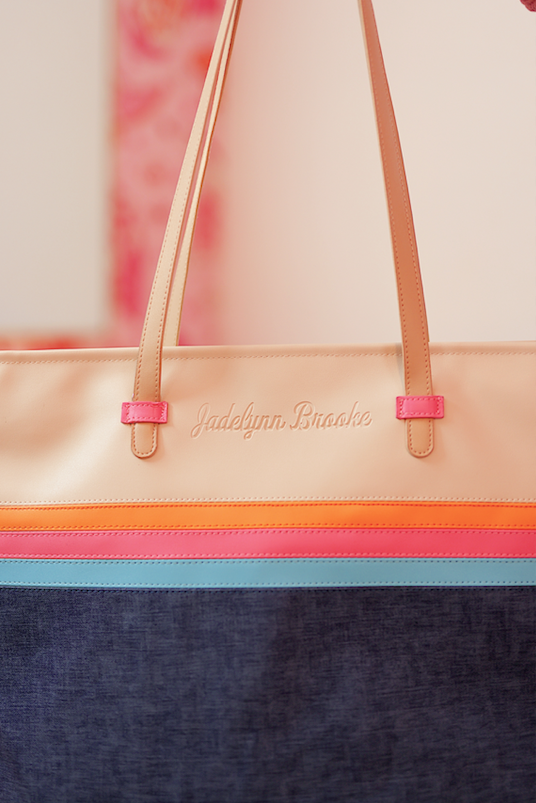 Stylish tote bag by Jadelynn Brooke, featuring beige, pink, and blue accents with durable denim material.