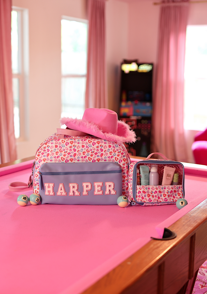 Pink leopard print kids' backpack with initials 'HARPER' and matching cosmetic case.